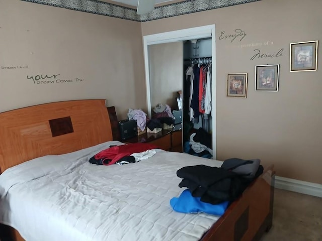 carpeted bedroom with a closet and baseboards