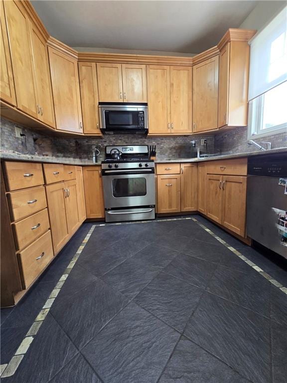 kitchen featuring stainless steel appliances, decorative backsplash, and inlaid floor details