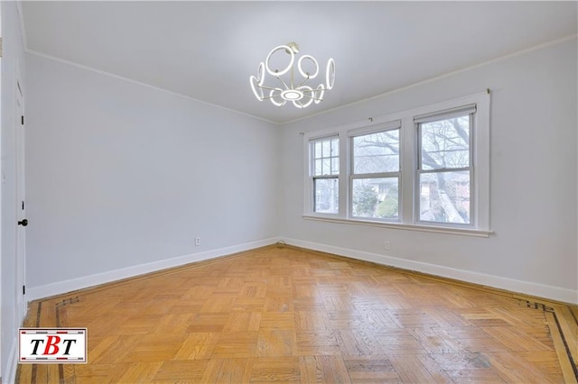 spare room featuring a chandelier, baseboards, and crown molding