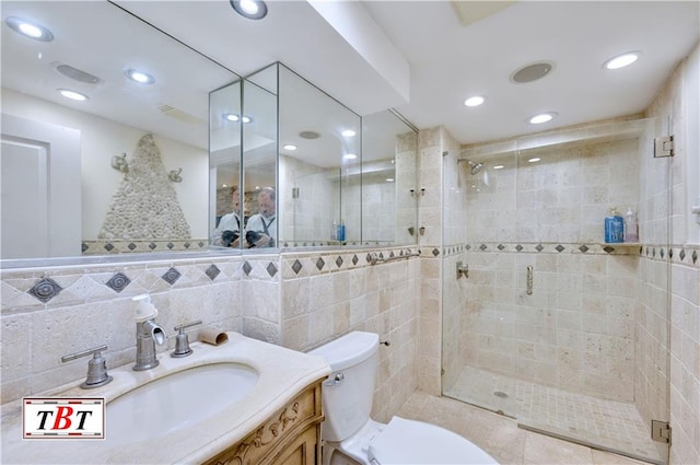 bathroom featuring a shower stall, toilet, vanity, tile walls, and recessed lighting