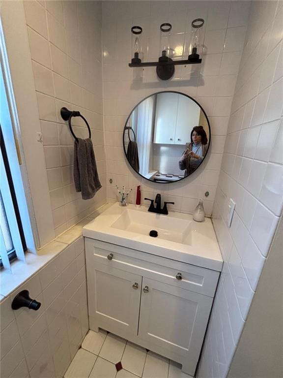 bathroom featuring tile patterned flooring, tile walls, vanity, and tasteful backsplash