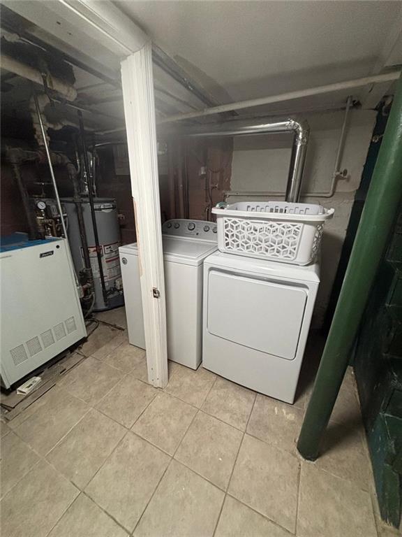 laundry area featuring light tile patterned flooring, gas water heater, and washer and dryer