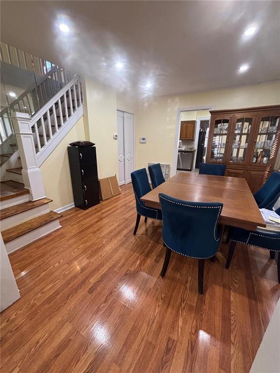 dining area with wood finished floors and stairs