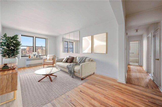 living room with wood finished floors and radiator heating unit