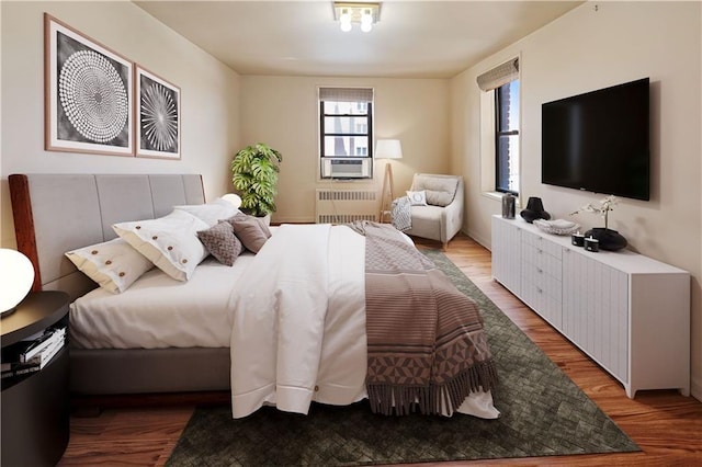 bedroom with radiator and wood finished floors