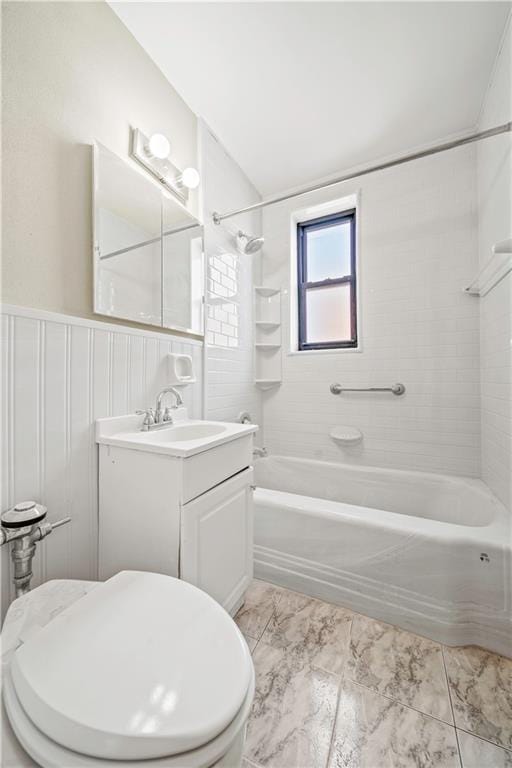 bathroom with vanity,  shower combination, toilet, and wainscoting