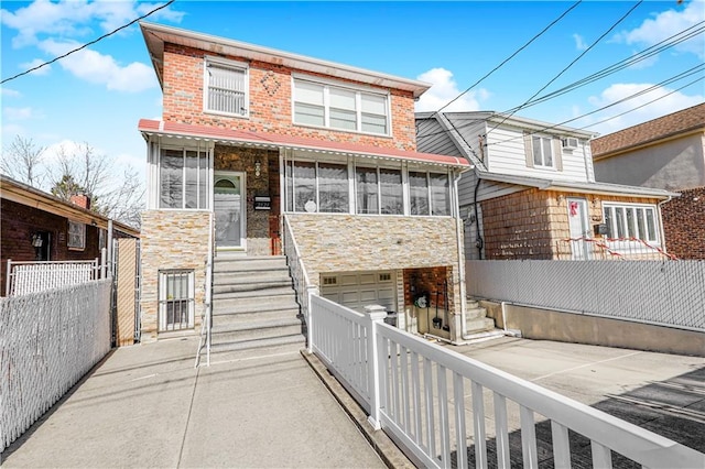 2121 Kimball St, Brooklyn, NY 11234 - rear view of house featuring stone siding, an attached garage, fence, and stairway