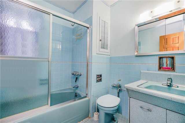 2121 Kimball St, Brooklyn, NY 11234 - bathroom featuring tile walls, vanity, toilet, enclosed tub / shower combo, and a wainscoted wall