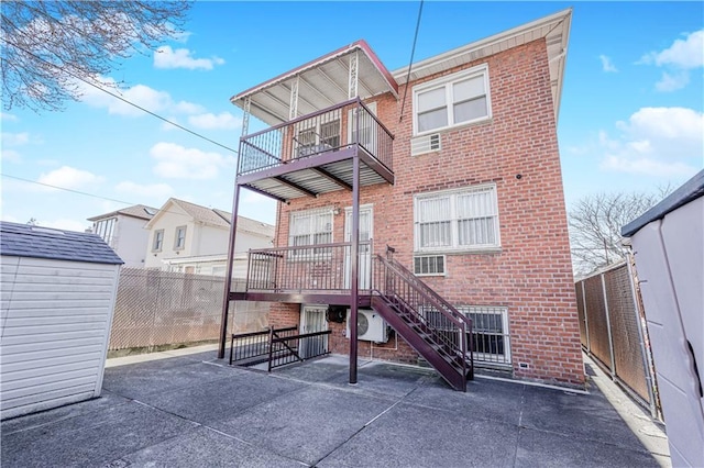2121 Kimball St, Brooklyn, NY 11234 - rear view of house featuring brick siding, fence, a balcony, an outdoor structure, and a patio