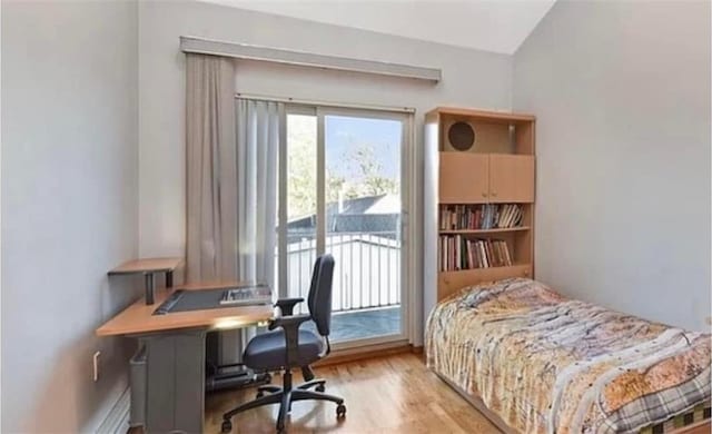 bedroom with access to outside, wood finished floors, and lofted ceiling