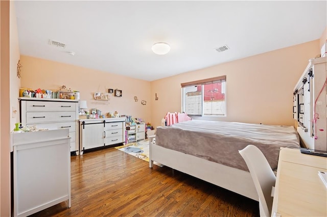 bedroom with visible vents and wood finished floors