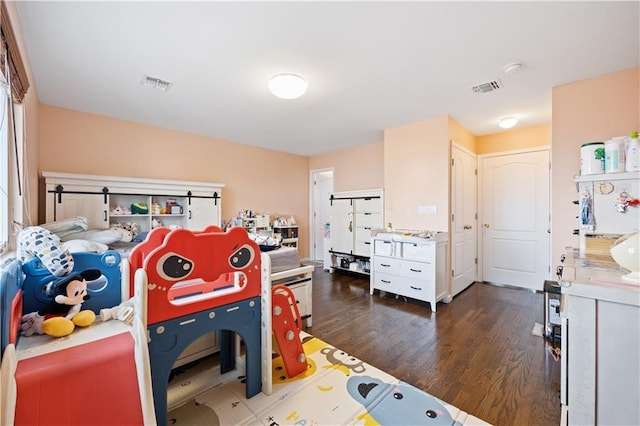 recreation room with dark wood-style floors and visible vents