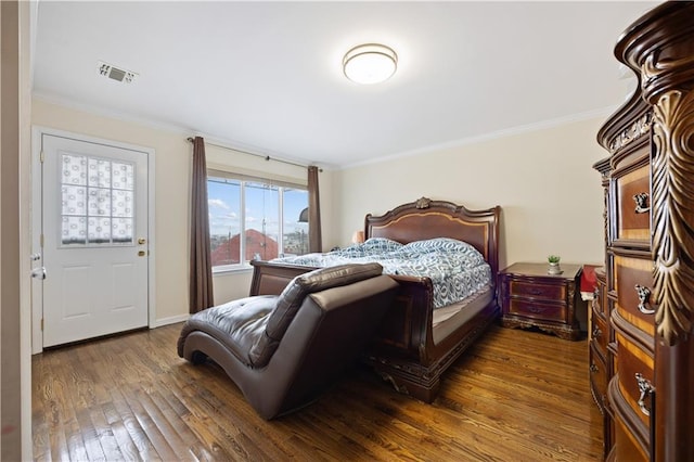 bedroom with baseboards, visible vents, wood finished floors, and crown molding