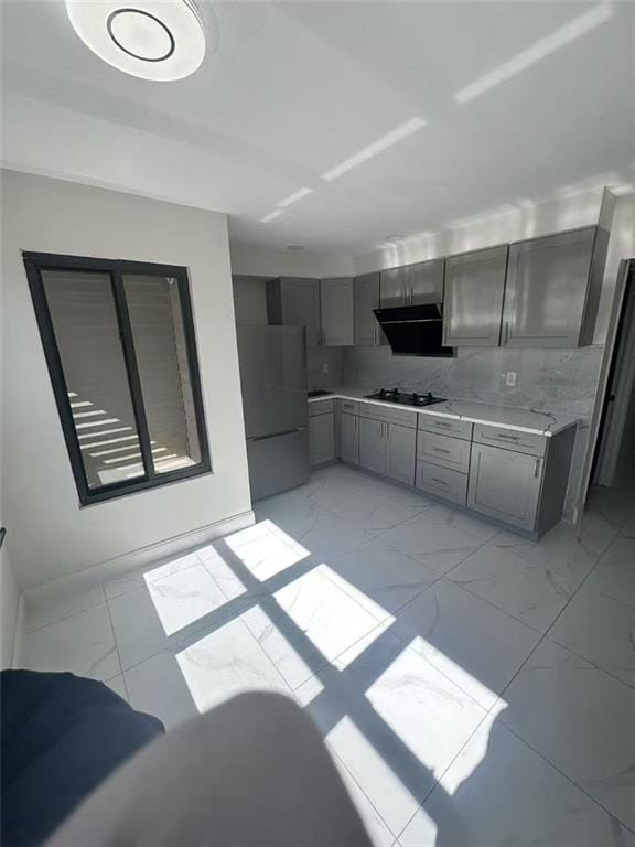 19 Drumgoole Rd, Staten Island, NY 10312 - kitchen with freestanding refrigerator, gray cabinets, light marble finish flooring, black gas cooktop, and light countertops