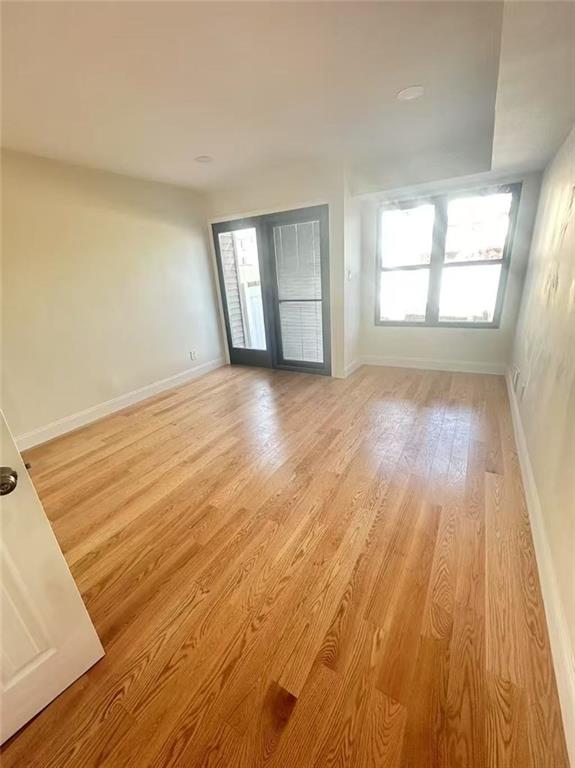 19 Drumgoole Rd, Staten Island, NY 10312 - empty room with baseboards, light wood finished floors, and healthy amount of natural light