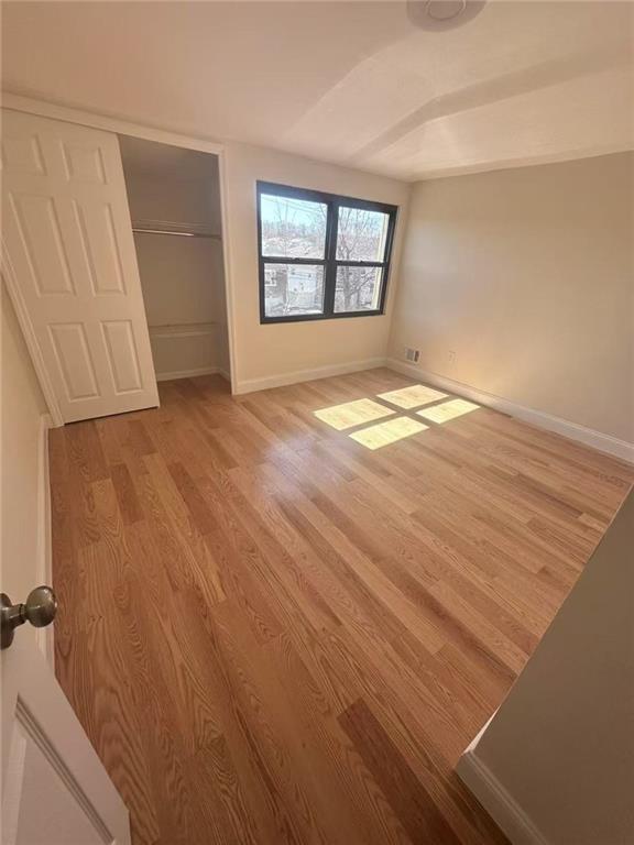 19 Drumgoole Rd, Staten Island, NY 10312 - unfurnished bedroom with light wood-style flooring, baseboards, and a closet