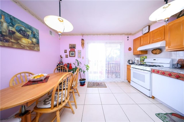 78 Townsend Ave, Staten Island, NY 10304 - kitchen with white range with gas stovetop, under cabinet range hood, light tile patterned flooring, hanging light fixtures, and light countertops