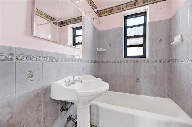 bathroom with tile walls and bathtub / shower combination