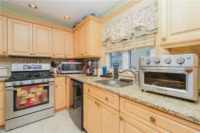 kitchen with stainless steel appliances, backsplash, a sink, and light stone counters