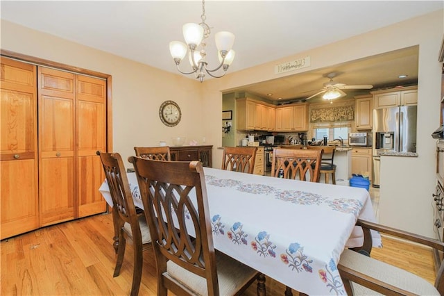 dining area with light wood finished floors, a chandelier, and ceiling fan