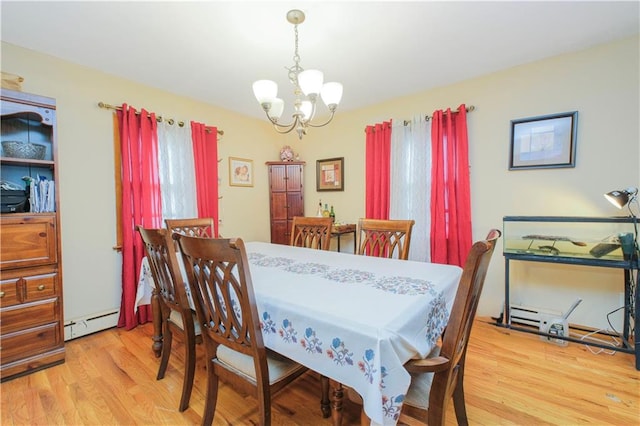 dining room with a chandelier, a baseboard heating unit, and wood finished floors
