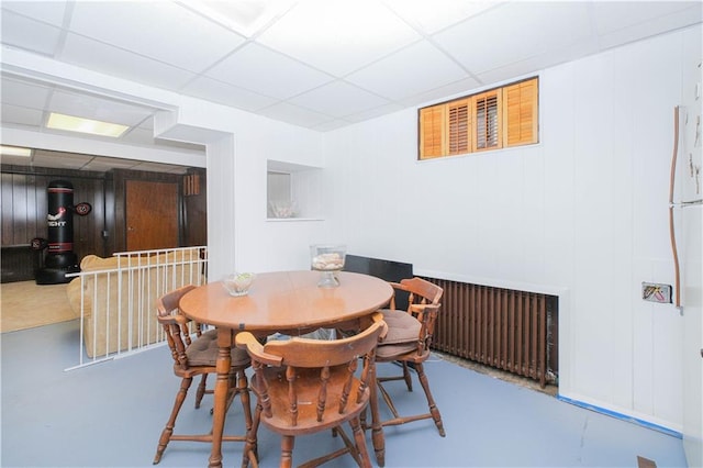 dining area with concrete floors and a paneled ceiling