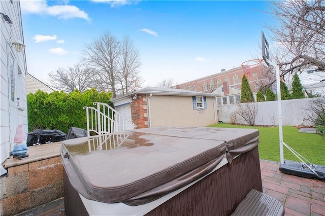 wooden deck with a hot tub and a garage