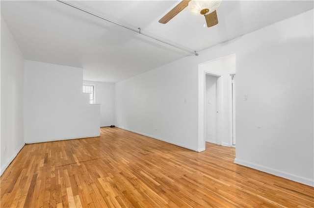 unfurnished room featuring light wood-style floors, a ceiling fan, and baseboards