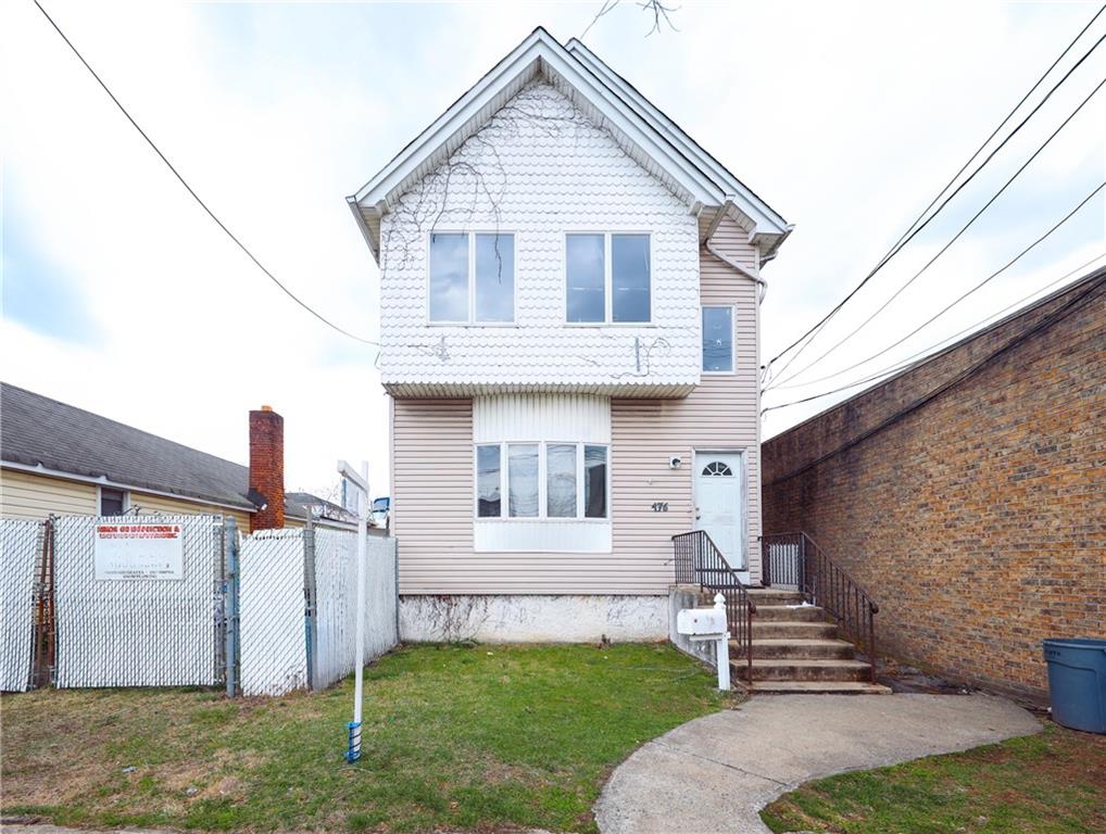 view of front of home with a front yard and fence