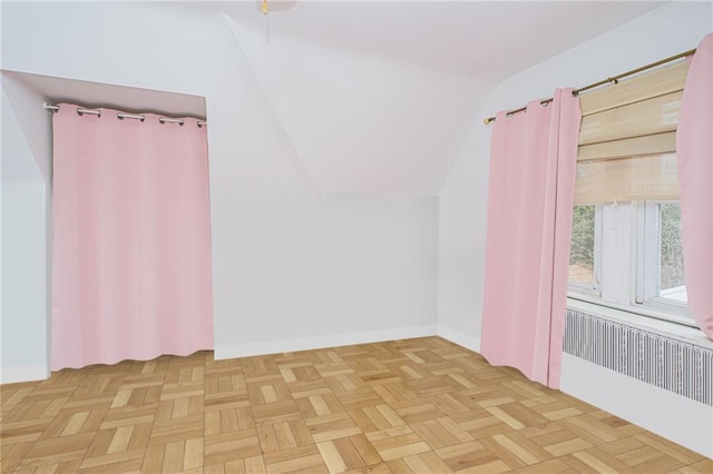 additional living space with baseboards, vaulted ceiling, and radiator heating unit
