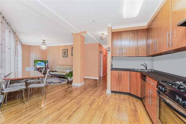 197 Bay 47th St Unit 5, Brooklyn, NY 11214 - kitchen with a sink, stainless steel appliances, brown cabinetry, light wood-style floors, and dark countertops