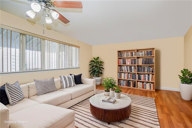living room with baseboards, ceiling fan, and wood finished floors