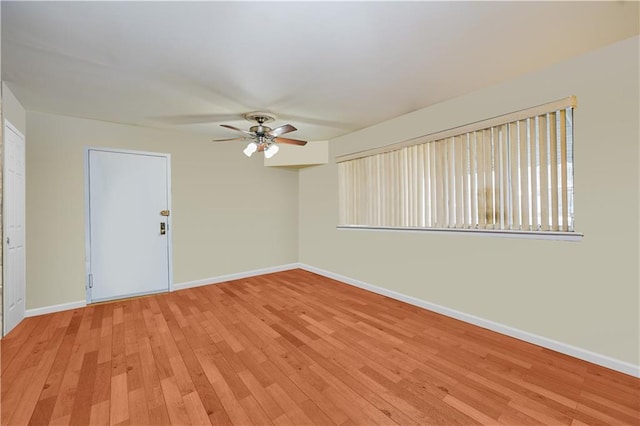 empty room with baseboards, light wood-style floors, and a ceiling fan