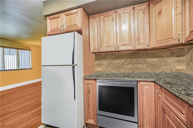 1310 84th St Unit 1A, Brooklyn, NY 11228 - kitchen with freestanding refrigerator, backsplash, baseboards, and light stone counters
