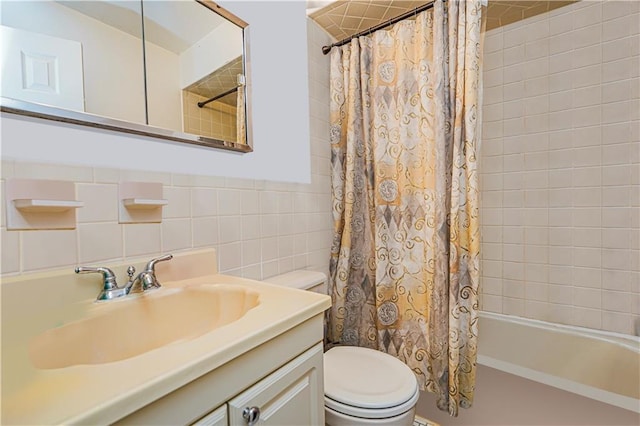 full bathroom with shower / tub combo, toilet, vanity, and tile walls