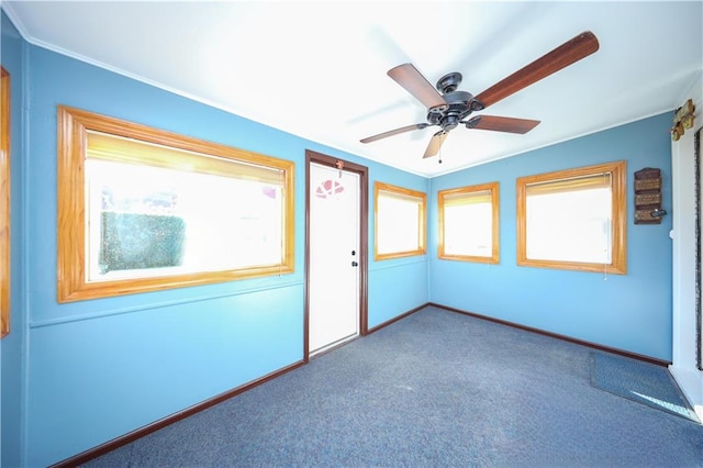empty room with ceiling fan, baseboards, and carpet