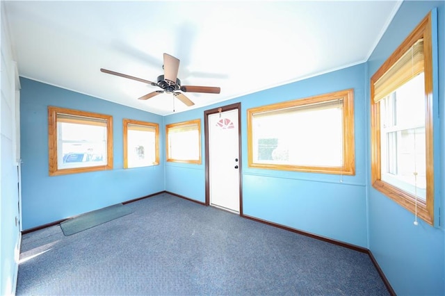 carpeted spare room with ceiling fan, baseboards, and ornamental molding