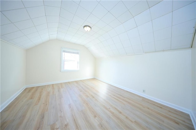 bonus room with baseboards, light wood finished floors, and lofted ceiling