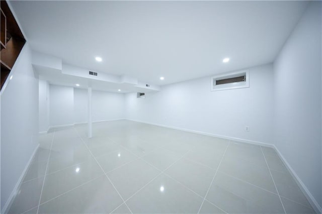 finished below grade area featuring tile patterned floors, baseboards, and recessed lighting