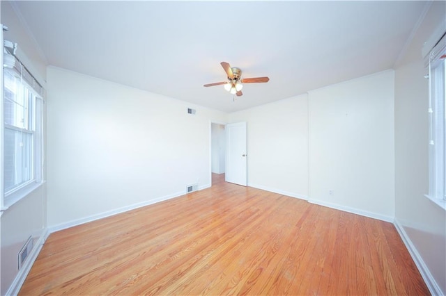 unfurnished room featuring light wood-type flooring, ceiling fan, and visible vents
