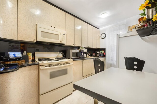 kitchen with light tile patterned floors and white appliances