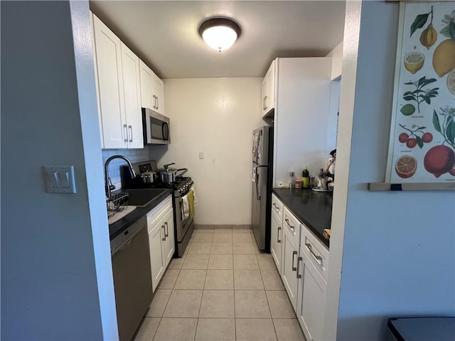 385 Douglass St Unit 3B, Brooklyn, NY 11217 - kitchen featuring appliances with stainless steel finishes, a sink, dark countertops, white cabinets, and light tile patterned flooring