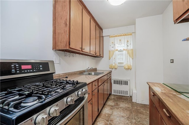 2928 W 5th St Unit 5F, Brooklyn, NY 11224 - kitchen featuring stainless steel range with gas stovetop, radiator heating unit, brown cabinets, and wooden counters