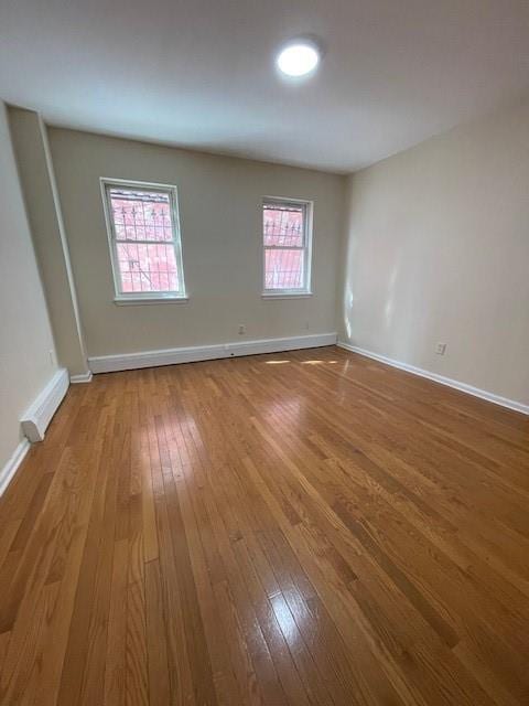 empty room featuring hardwood / wood-style floors and baseboards