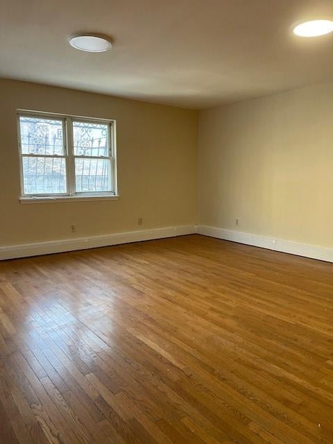 empty room featuring hardwood / wood-style floors and baseboards
