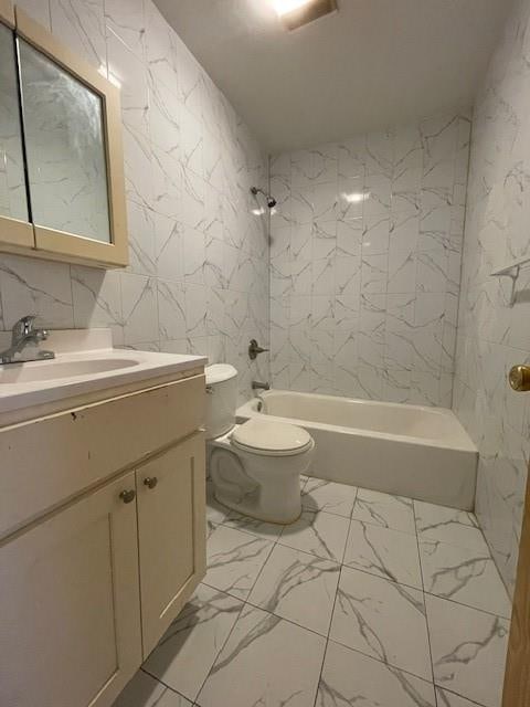 bathroom with marble look tiles, shower / tub combination, toilet, and vanity