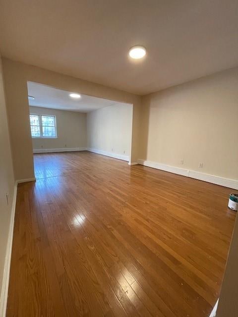 spare room with wood-type flooring, baseboards, and recessed lighting