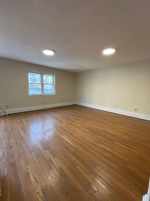 empty room featuring dark wood finished floors and baseboards