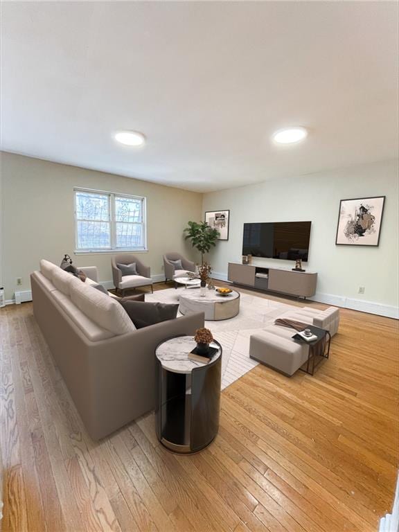 living room featuring hardwood / wood-style floors, baseboards, and recessed lighting