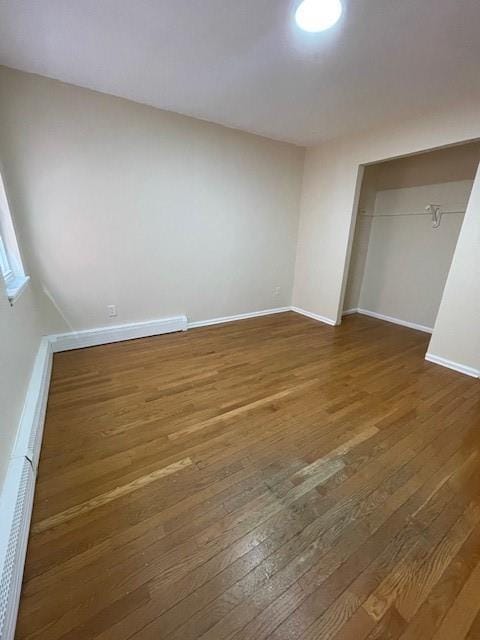 unfurnished bedroom featuring wood-type flooring, baseboards, and a closet